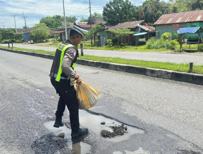 Personel Satlantas Polres Barru melakukan perbaikan sementara jalan berlubang di Jalan Poros Barru–Parepare untuk mencegah kecelakaan lalu lintas.